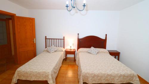 a bedroom with two beds and a chandelier at 411 Finca Sa Costa ETV1976 by Mallorca Charme in Campos