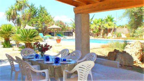 a table and chairs on a patio next to a pool at 409 Villa Can Bril ETV1523 by Mallorca Charme in Campos
