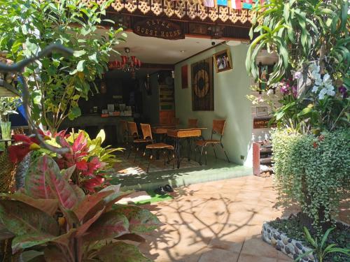 um pátio com uma mesa, cadeiras e plantas em TAVEE Guesthouse em Bangkok