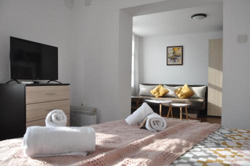 1 dormitorio con 1 cama con toallas en Honey I`m home Apartments, en Veliko Tŭrnovo