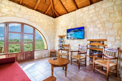 a living room with a couch and a table and chairs at Villa Ostria in Georgioupolis