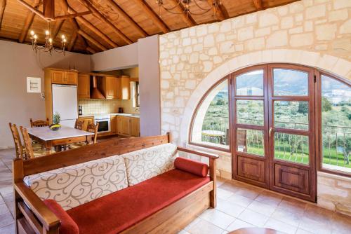 a kitchen and dining room with a large window at Villa Ostria in Georgioupolis