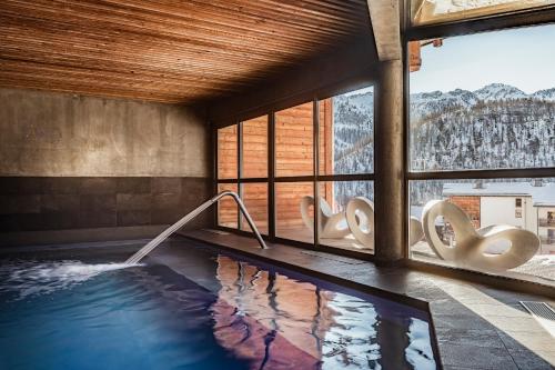 une piscine avec vue sur les montagnes dans l'établissement Le Bois du Suffin, Pied de pistes et Spa, à Montgenèvre