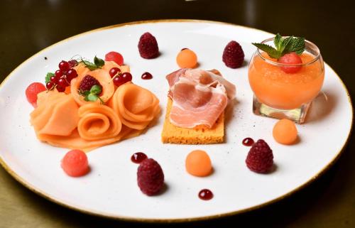 a plate of food with fruit and a drink at Mercure Dijon Centre Clemenceau in Dijon