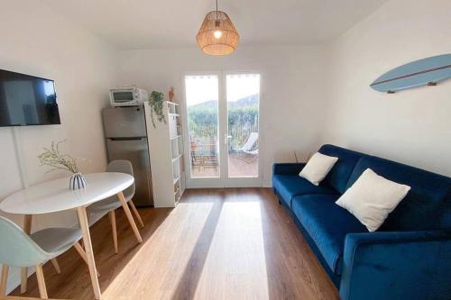 un salon avec un canapé bleu et une table dans l'établissement Studio à deux pas des plages de Biscarrosse, wifi, à Biscarrosse