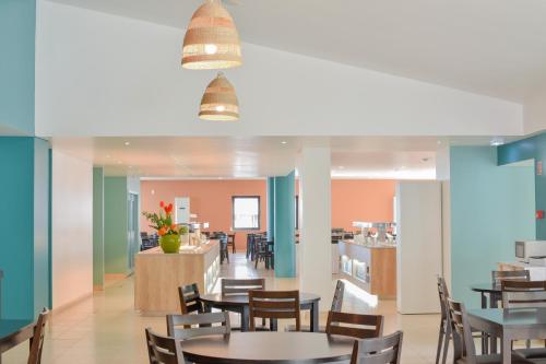 a restaurant with tables and chairs and a counter at Golden Club Cabanas in Cabanas de Tavira