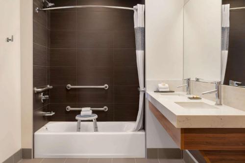 a bathroom with a tub and a toilet and a sink at La Quinta by Wyndham San Luis Obispo in San Luis Obispo