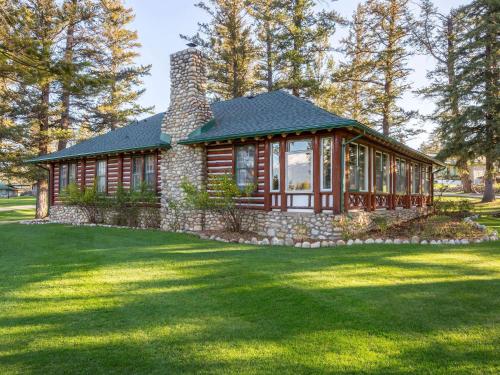 a small log cabin with a grass yard at Fairmont Jasper Park Lodge in Jasper