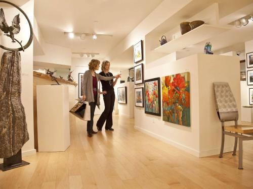 two women standing in a gallery looking at art at Fairmont Jasper Park Lodge in Jasper