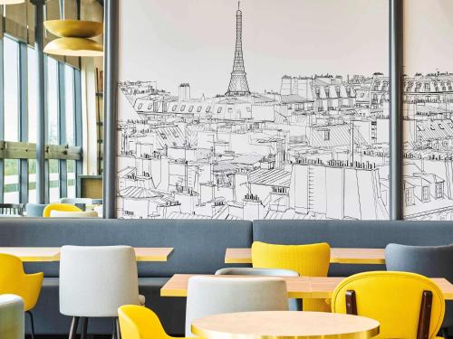 a restaurant with tables and chairs and a drawing of the eiffel tower at ibis Paris Porte de Montreuil in Paris