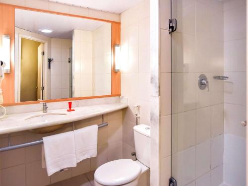 a bathroom with a toilet and a sink and a shower at ibis Sao Luis in São Luís