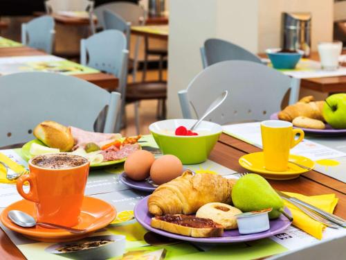 a table topped with plates of food and cups of coffee at Ibis Styles Milano Centro in Milan