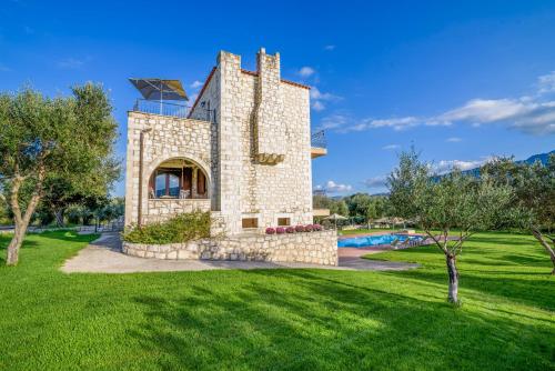 a stone house with a pool in a park at Villa Ostria in Georgioupolis