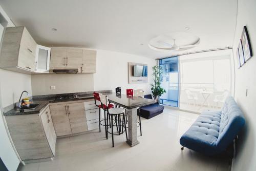 cocina con mesa y sofá azul en una habitación en Apartamento Welch, en Cartagena de Indias
