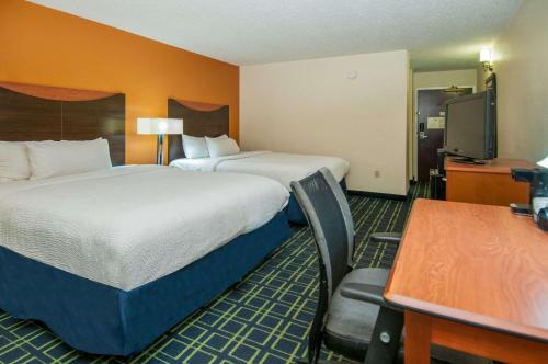 a hotel room with two beds and a desk and a table at Quality Inn & Suites in Jackson