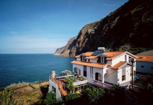 a house on a hill next to the ocean at Cecília's House in Jardim do Mar