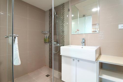 ein Badezimmer mit einem weißen Waschbecken und einer Dusche in der Unterkunft Clownfish Resort in Altstadt von Hengchun