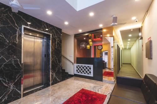 a lobby with a elevator with a red rug at SKM REGENCY in Chennai