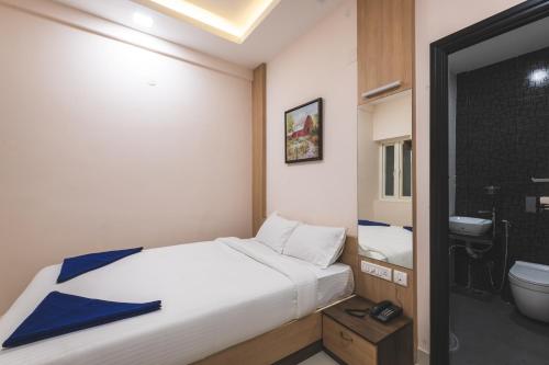 a bedroom with a bed and a bathroom with a toilet at SKM REGENCY in Chennai