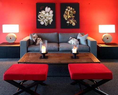 a living room with a couch and red walls at Waldsee Golf-Resort in Bad Waldsee