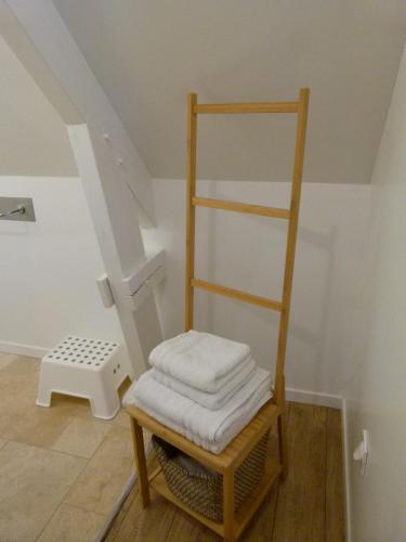 une échelle en bois assise dans une pièce avec un tabouret dans l'établissement DEAUVILLE 5 min, La Cabane des Princesses, à Bonneville-sur-Touques