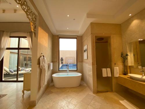 a large bathroom with a tub and a sink at Western Hotel - Madinat Zayed in Madīnat Zāyid