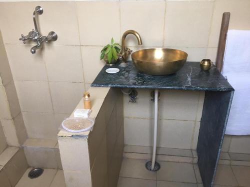 łazienka z umywalką i miską na ladzie w obiekcie Panchkote Raj Ganges w mieście Waranasi