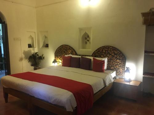 a bedroom with a large bed with red pillows at Panchkote Raj Ganges in Varanasi