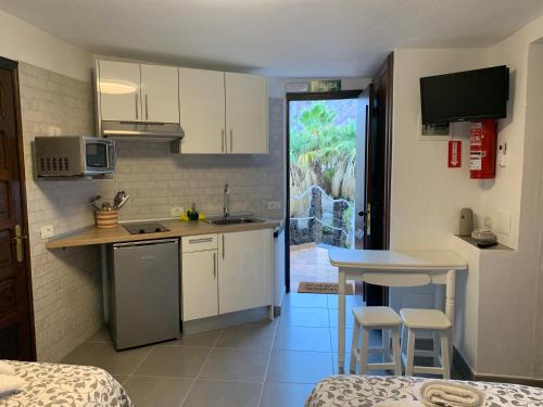 a small kitchen with white cabinets and a counter top at Apartamentos Finca Wapa in Frontera