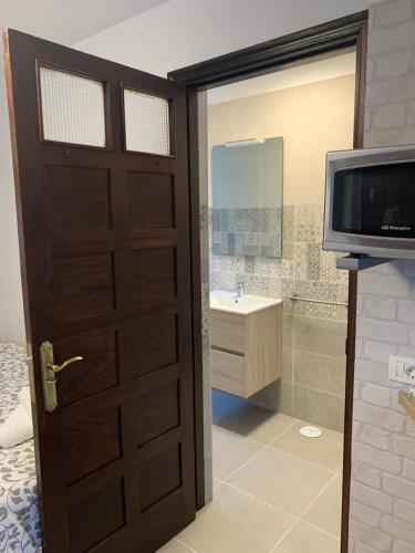 a door to a bathroom with a television and a sink at Apartamentos Finca Wapa in Frontera