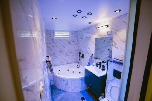 baño azul y blanco con bañera y lavamanos en Orel suite en Eilat