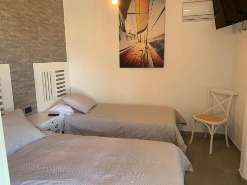 a bedroom with two beds and a picture on the wall at Apartamentos Finca Wapa in Frontera