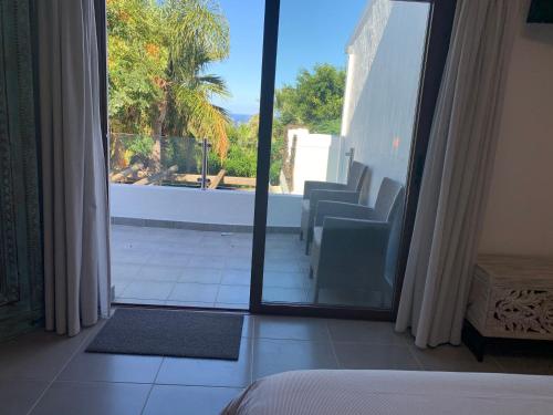 a bedroom with a view of a patio with chairs at Apartamentos Finca Wapa in Frontera