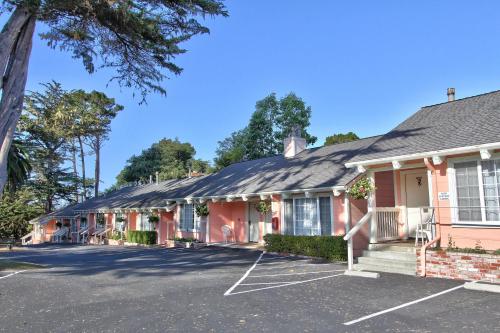 a pink building with a parking lot at Butterfly Grove Inn in Pacific Grove