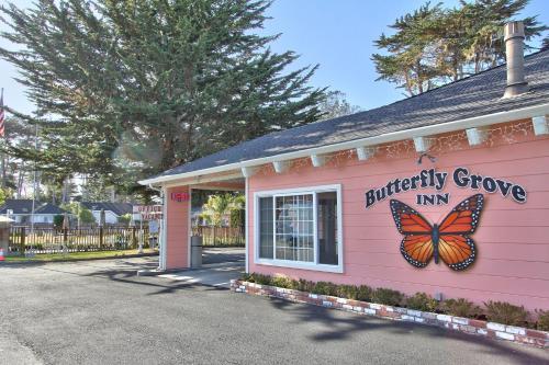 a pink building with a butterfly growin sign on it at Butterfly Grove Inn in Pacific Grove