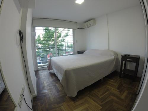 a bedroom with a bed and a large window at Torre Angel - Fragueiro 325 in Córdoba