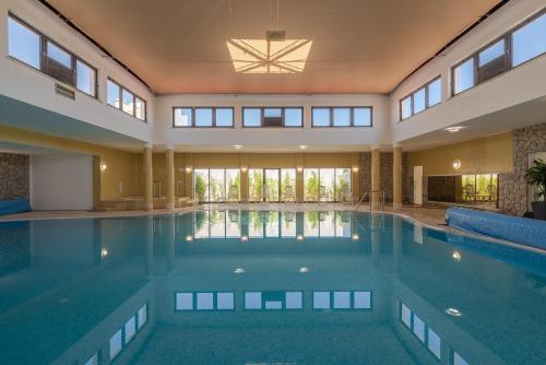 a large swimming pool in a house with windows at Golden Club Cabanas in Cabanas de Tavira