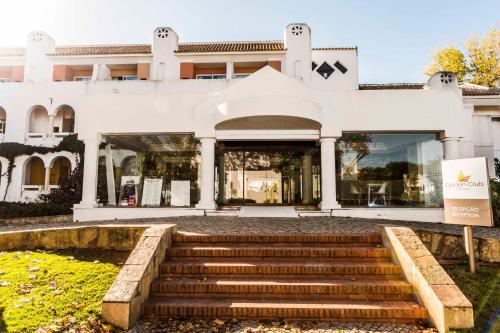 a white building with stairs in front of it at Golden Club Cabanas in Cabanas de Tavira