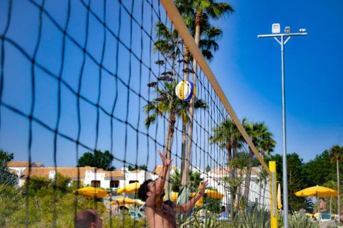 a woman hitting a volleyball in a volley ball net at Golden Club Cabanas in Cabanas de Tavira