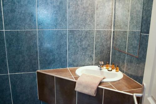 a bathroom with a sink and a tiled wall at La MAISON du PORT in Port-Cros