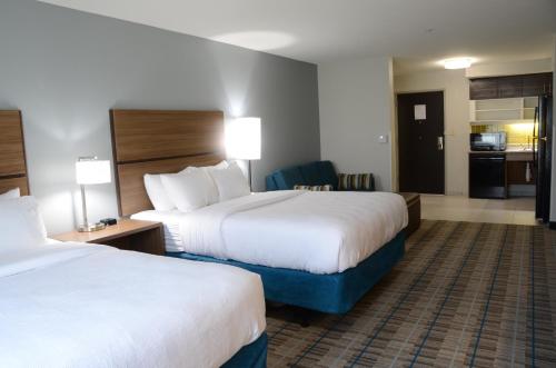 a hotel room with two beds and a kitchen at MainStay Suites Bowling Green North in Bowling Green