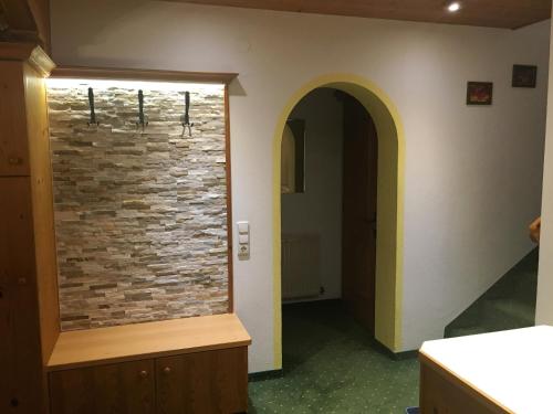 un pasillo con una pared de ladrillo y una entrada en Haus Marco, en Neustift im Stubaital