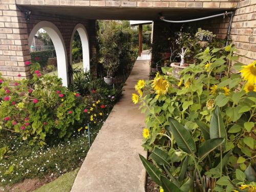 a garden with flowers and a walkway at Beautiful Sea View Room in Jeffreys Bay