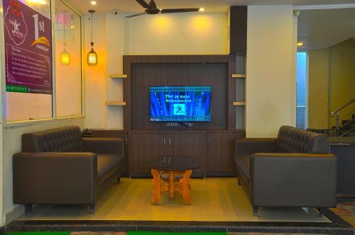 a waiting room with two chairs and a table and a tv at JK Rooms 126 Parashar Legacy - Opp Railway Station in Nagpur