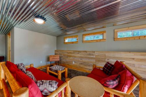 a living room with a red couch and a table at Private Franconia Log Cabin in Franconia