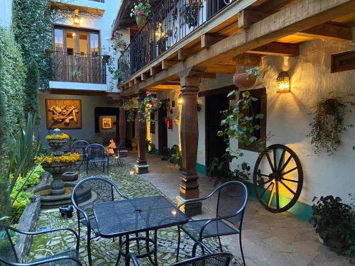 a patio with tables and chairs and a building at Hotel Mi Pueblito Tapalpa in Tapalpa