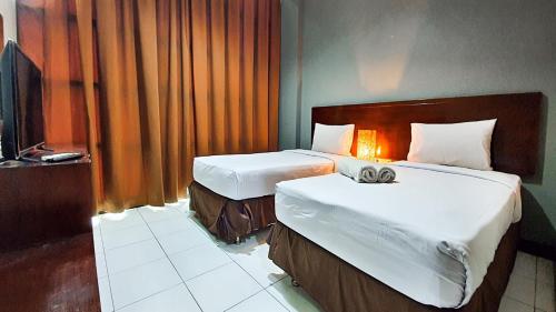 Cette chambre comprend deux lits et une télévision. dans l'établissement N hotel Tanah Abang, à Jakarta