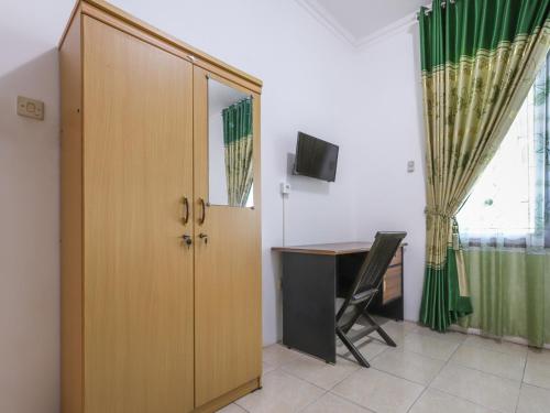 Zimmer mit einem Schreibtisch, einer Tür und einem Tisch in der Unterkunft OYO 3789 Bukit Somber Residence Syariah in Kampung Baru
