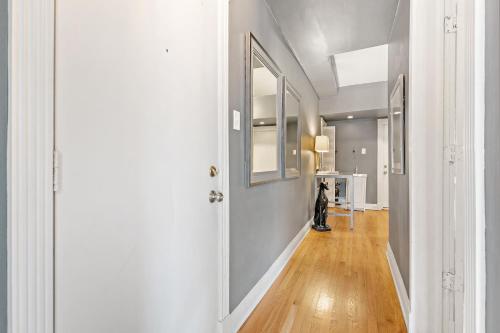 um corredor com paredes brancas e uma pessoa de pé na porta em Trendy 2BR Apartment with Modern Amenities - Halsted 2A em Chicago