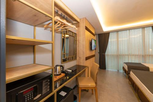 a small room with a bed and a desk in a room at Fly And Stay Airport Hotel in Istanbul